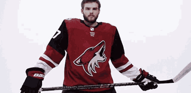 a hockey player wearing a red and black jersey with the number 7 on it