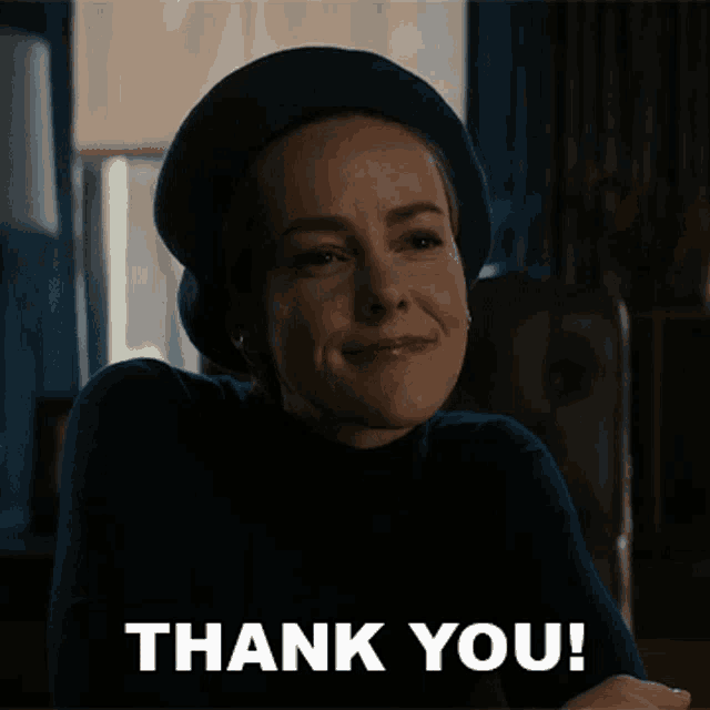 a woman wearing a beret is smiling with the words thank you below her