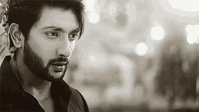 a black and white photo of a man with a beard and a scarf around his ear .