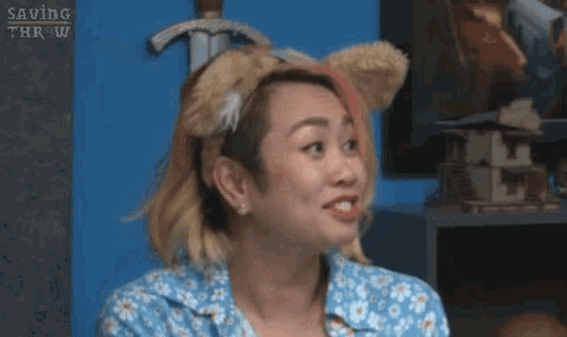 a woman wearing a teddy bear headband is giving the peace sign