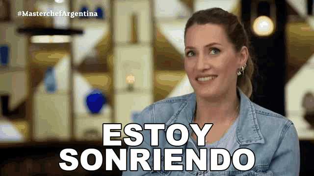 a woman in a denim jacket is smiling with the words estoy sonriendo behind her