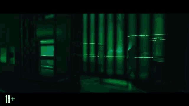 a man is holding a gun with a green light coming out of it