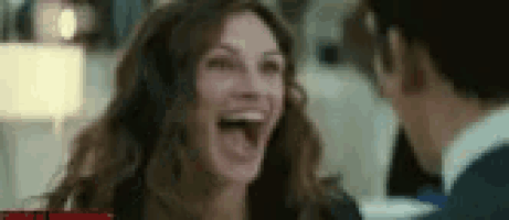a woman is laughing while talking to a man in a restaurant .