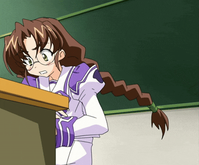 a girl with braided hair and glasses stands behind a desk in front of a blackboard