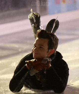 a man is laying on the ice wearing ice skates on his head