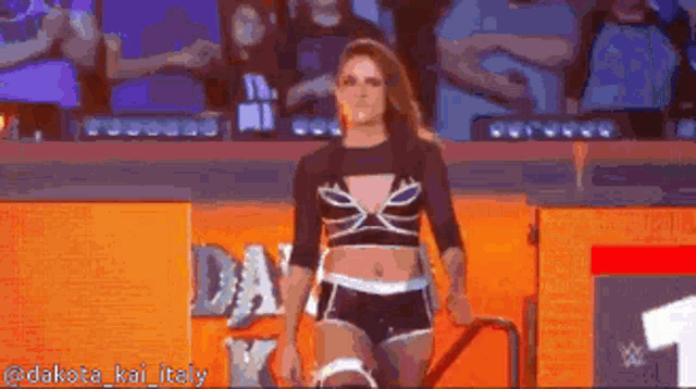 a woman in a black top and shorts is walking down stairs in front of a dakota kai italy sign