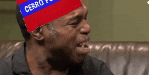 a man is sitting on a couch with a cerro flag on his head .