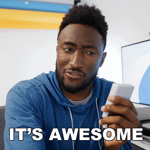 a man holding a cell phone with the words it 's awesome behind him