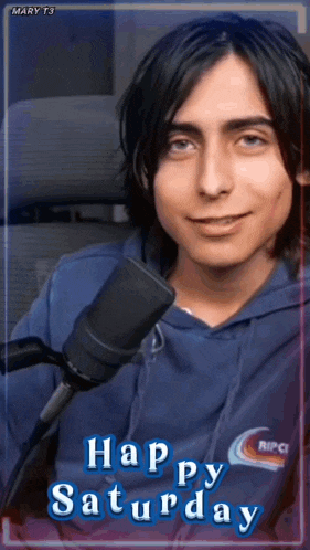 a man in a blue hoodie is smiling in front of a microphone and the words happy saturday are above him