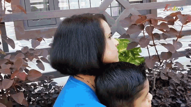 a woman holds a child on her shoulders with the word kidcoo written on the bottom