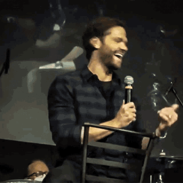 a man in a plaid shirt is holding a microphone