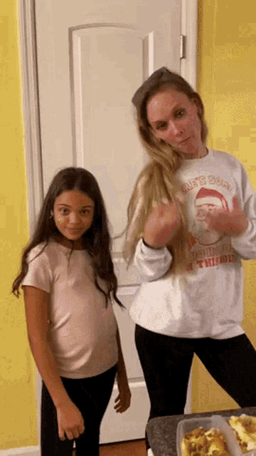 a woman wearing a sweatshirt that says " it 's okay " is standing next to another woman