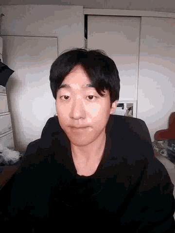 a man in a black shirt is standing in a room