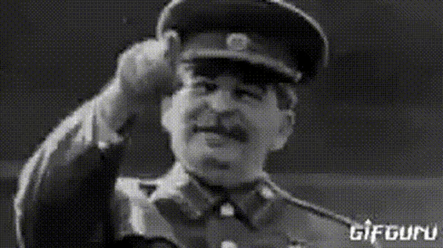 a black and white image of a man in a military uniform saluting .