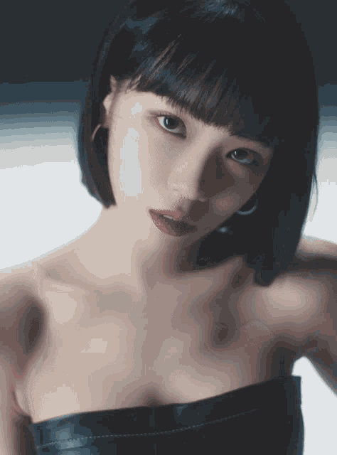 a woman with short black hair and red lips is wearing a strapless black top