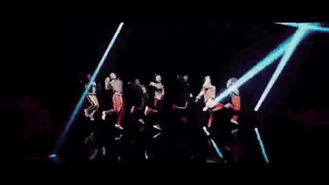 a group of people are dancing in front of a neon sign that says baby