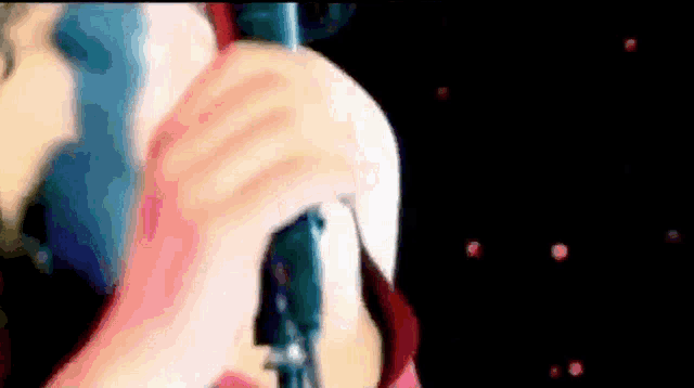 a person is singing into a microphone in a dark room