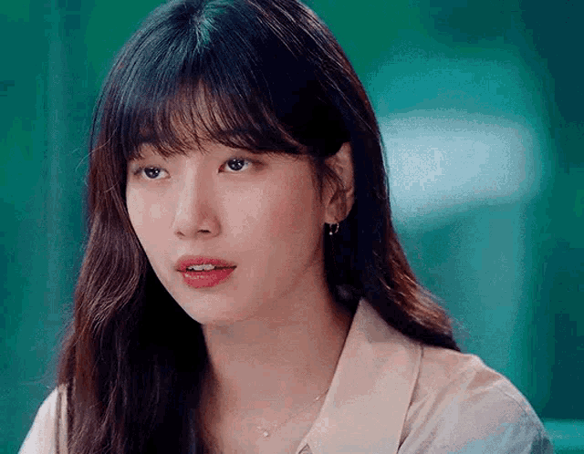 a close up of a woman 's face with long hair and bangs
