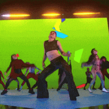 a group of people are dancing on a stage with a green background