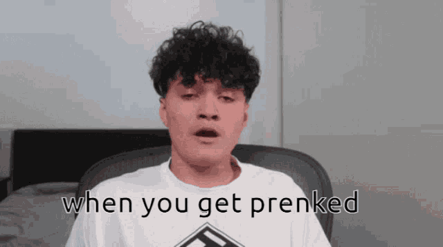 a man with curly hair is wearing a white shirt that says " when you get precked "