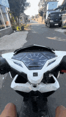 a person is riding a honda scooter down a road