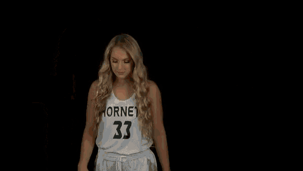 sarah abney # 3 stands in front of a dark background