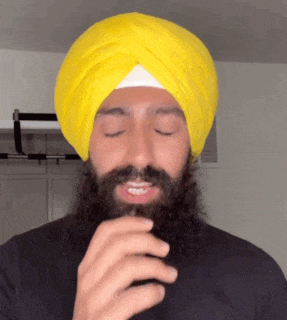 a man with a beard wears a yellow turban