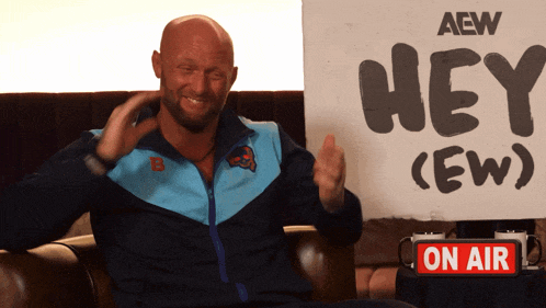 a man in a blue jacket holds a sign that says hey ( ew )