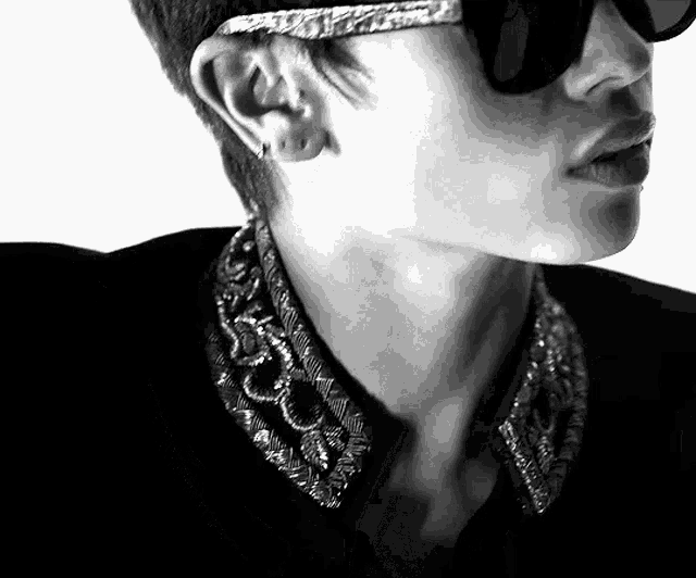 a black and white photo of a man wearing sunglasses and earrings
