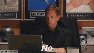 a man is sitting in front of a laptop with the word no on the screen