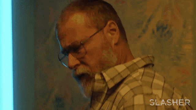 a man in a plaid shirt is talking on a cell phone with the words crazy bitch below him