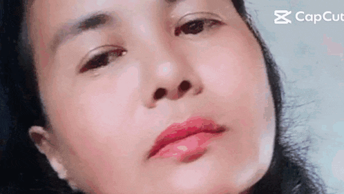 a close up of a woman 's face with her eyes closed and red lipstick on her lips .