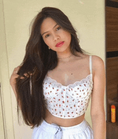 a woman wearing a white crop top and white shorts