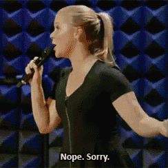 a woman is singing into a microphone and saying nope sorry