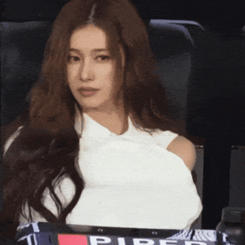 a woman in a white top is sitting in a chair with the word pipe on the seat
