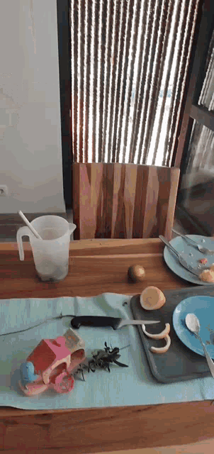 a table with a pitcher a knife and a tray of lemon slices on it