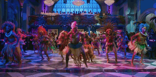 a group of people are dancing on a checkered floor and one of them is wearing a feathered headpiece