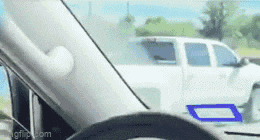a white truck is parked in a parking lot with a blue sticker on the windshield