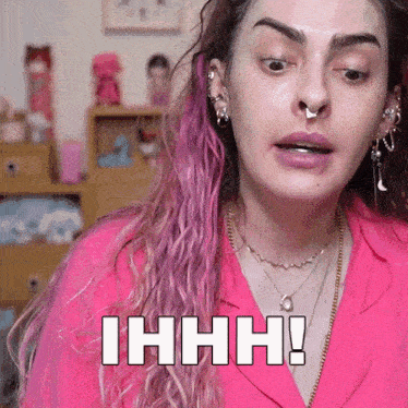 a woman with pink hair is making a funny face and says ihhhh