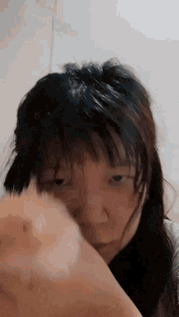 a close up of a woman 's face with her hand on her face