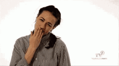 a woman in a striped shirt is pointing at the camera .