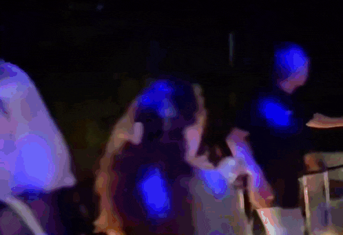 a blurry picture of a crowd of people dancing in the dark