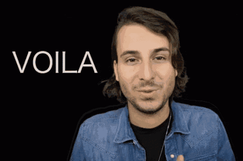 a man in a denim jacket is smiling in front of a black background with the word voila on it