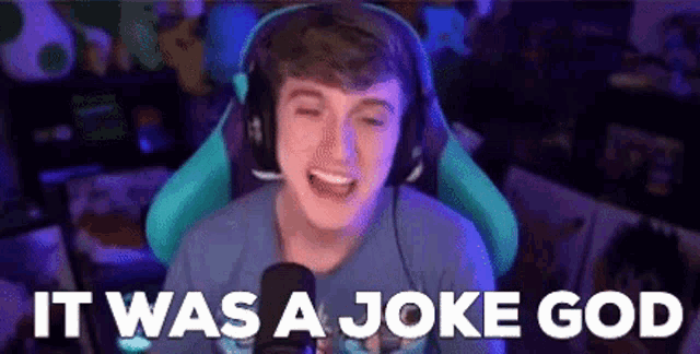a man wearing headphones and a blue shirt is sitting in front of a microphone and says `` it was a joke god ''