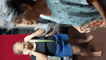 a woman measuring another woman 's waist with a measuring tape
