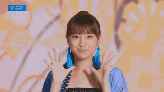 a girl with a ponytail is smiling and wearing a blue shirt that says up front works