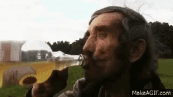 a man with a beard is drinking a beer from a bottle .