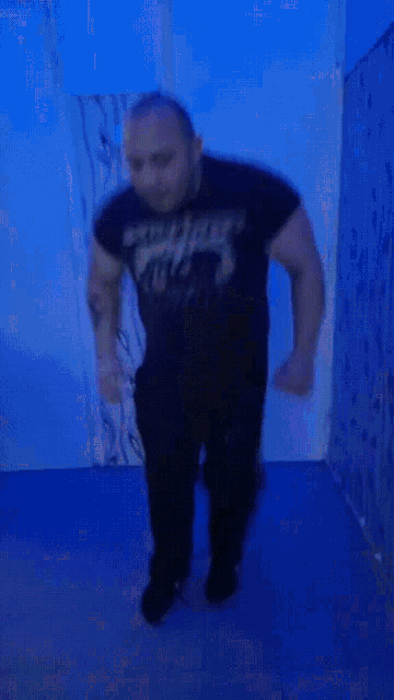 a man in a black shirt that says ' slayer ' on it is jumping in the air