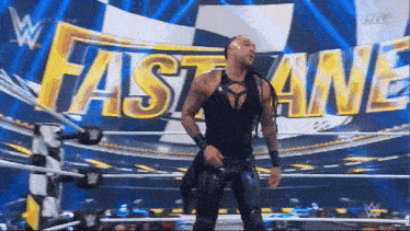 a wrestler stands in front of the fastlane sign