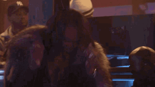 a woman in a fur coat is laughing in front of a purple light